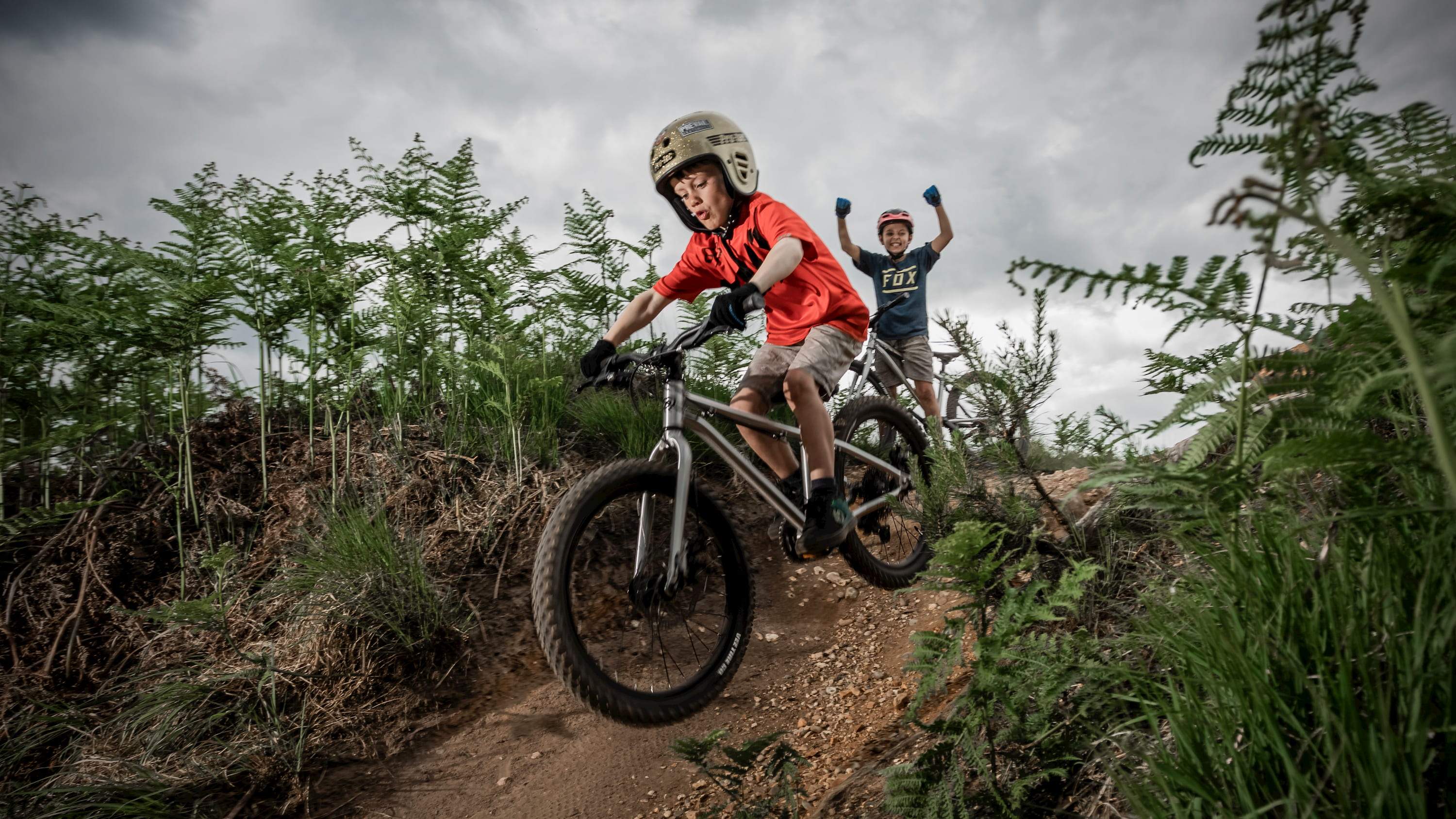 Kid riding Seeker 20 along a forest trail